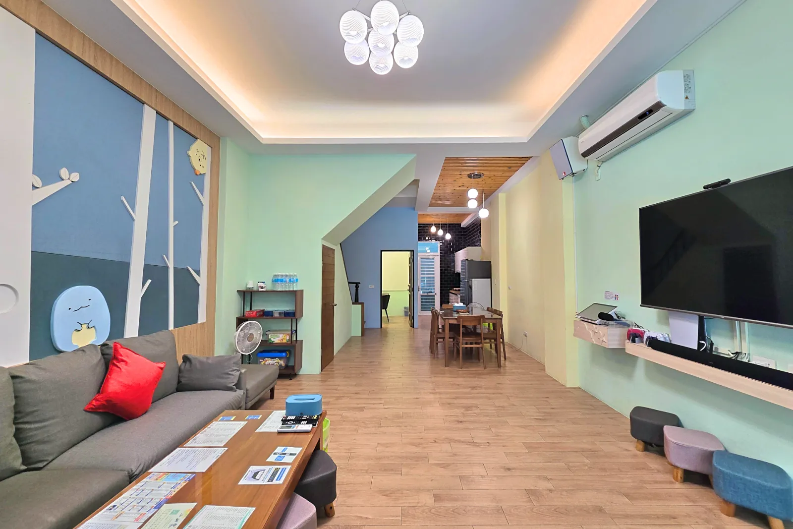 一樓大廳客廳望向餐桌與電視牆的開放式空間