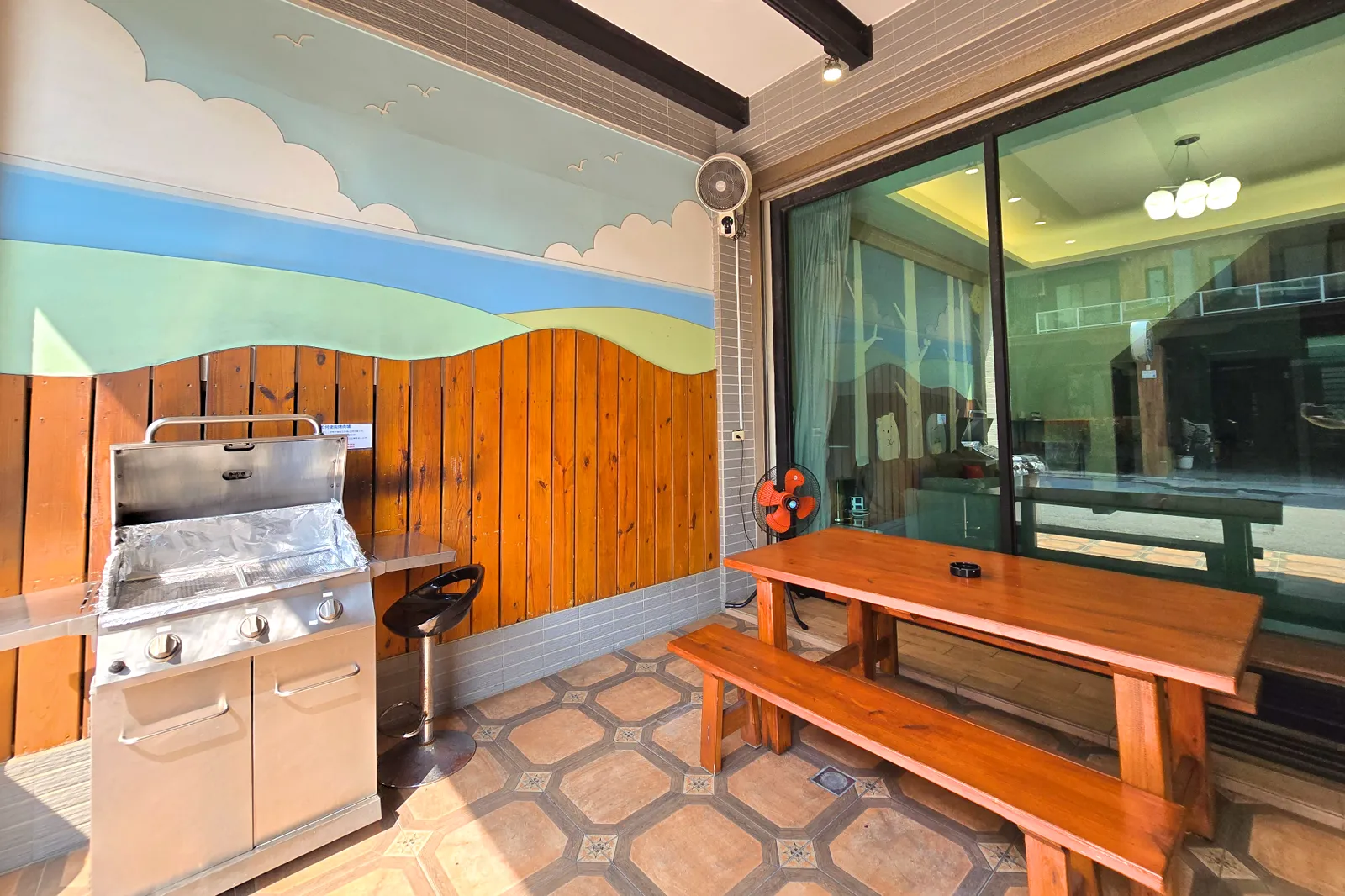 前庭烤肉空間近景，可見大型烤肉爐與木質桌椅座位