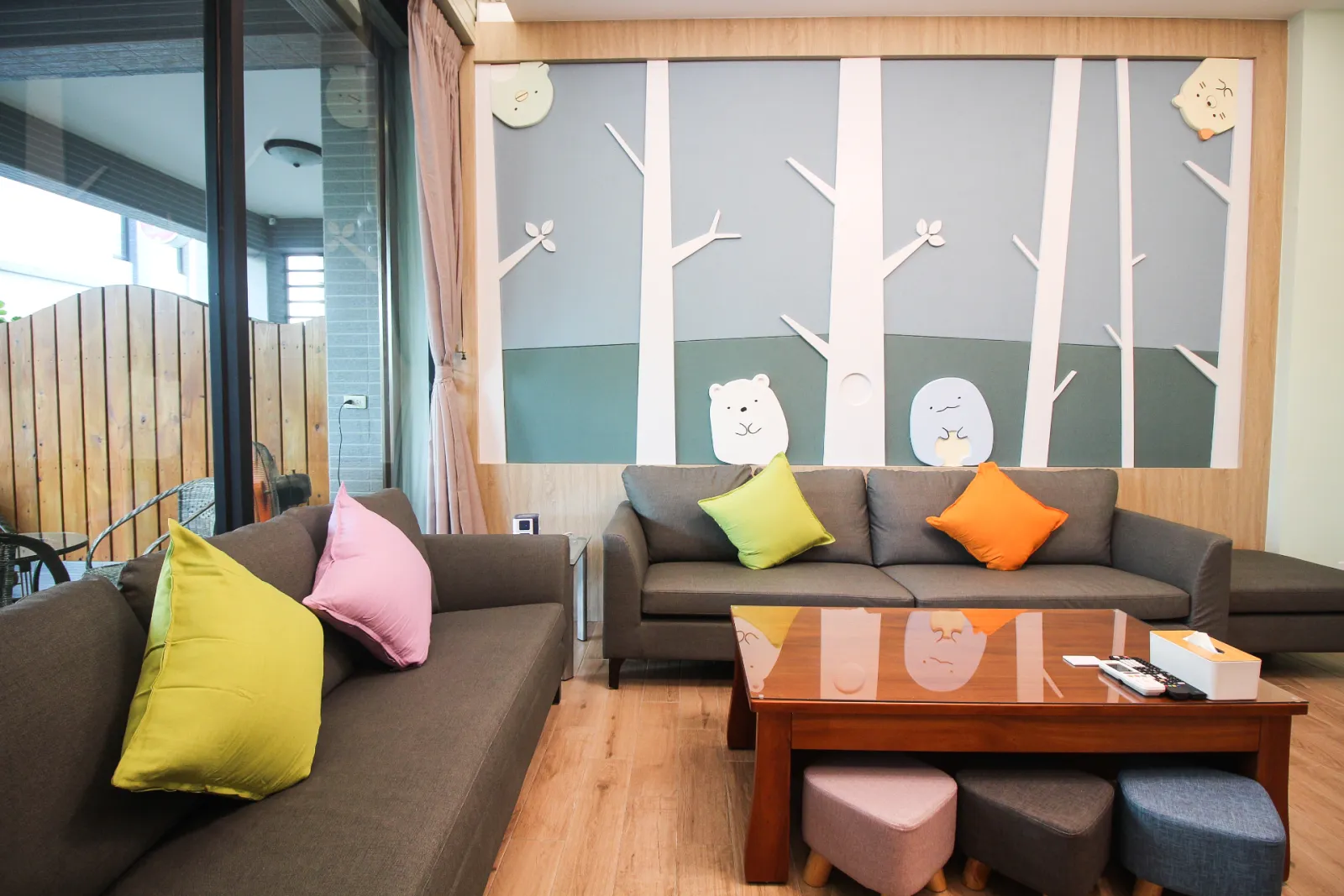 一樓客廳沙發區近景，搭配森林主題牆面